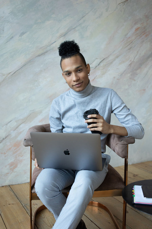 ragazzo-seduto-su-una-sedia-beve-caffè-e-lavora-al-computer