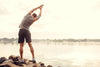 uomo in riva al lago pratica esercizi di mobilità circolare