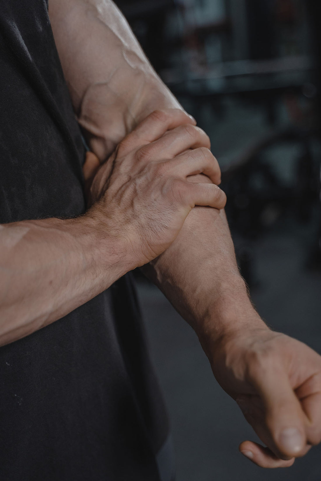 uomo-in-piedi-si-tocca-avambraccio-sinistro-con-la-mano-destra